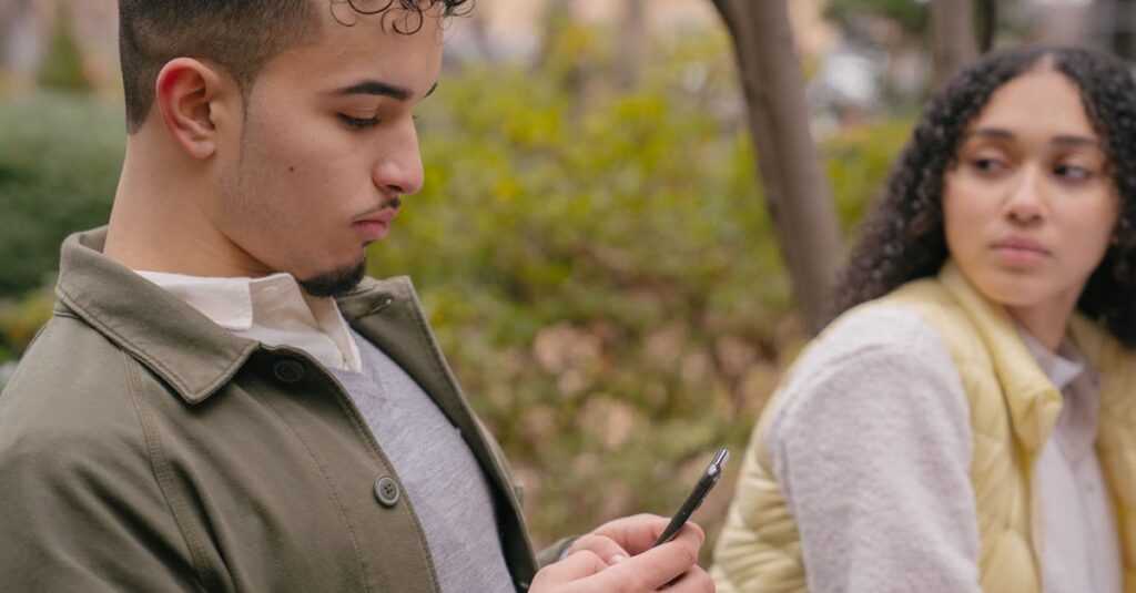 A young couple sitting outdoors with a smartphone, capturing casual moments and emotions.